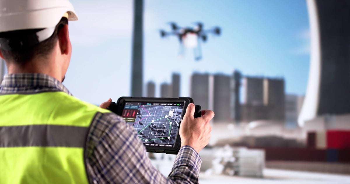 Technician inspecting oil refinery pipes using drone