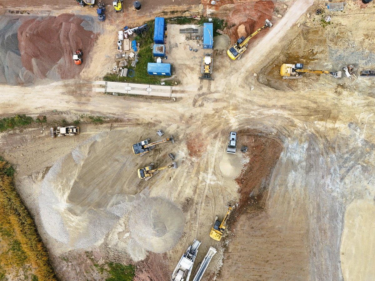 Top-down view of active construction site with heavy machinery